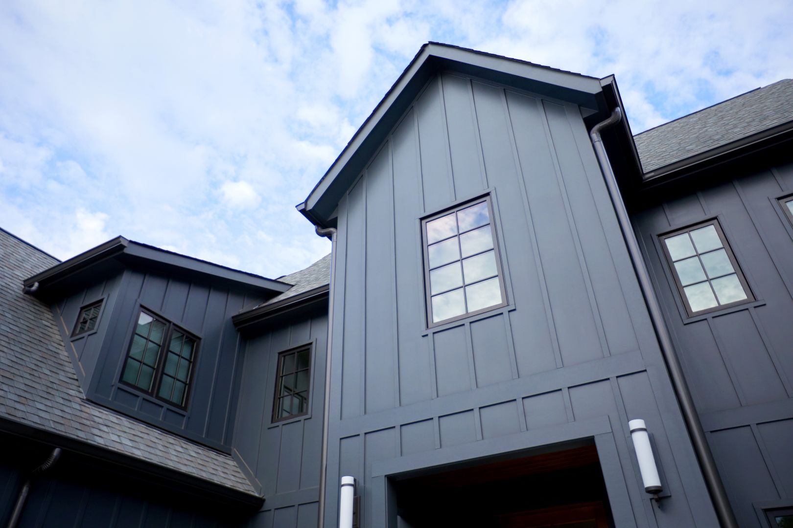 Dark bronze exterior clad Jeld Wen Siteline® wood casement windows installed on vertical board and batten Modern Farmhouse siding